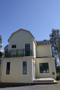 The hostel house seen from below, with the balcony on the upper floor