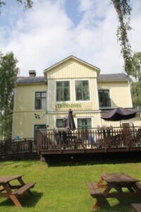 The gable of Strömsborg with the terrace and picnic tables on the lawn in front