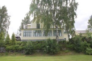 Strömsborg’s glazed veranda seen from the lawn, behind a large birch